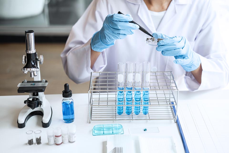 Scientist or medical in lab testing sample trial with reagent, mixing reagents in glass flask, glassware containing chemical liquid, laboratory research and testing of Microscope.